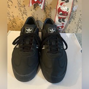 Women’s Adidas samba leather black with silver details. Will fit a size 8